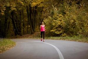 joven fitness mujer corriendo en pista forestal foto