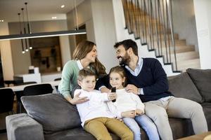 Young family watching TV together on the sofa in the living room photo