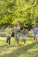 grupo de niños asiáticos y caucásicos divirtiéndose en el parque foto