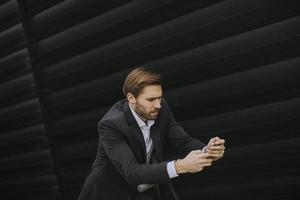 Young businessman using mobile phone  on electric scooter photo