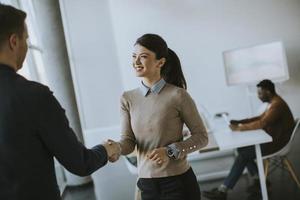 Young business partners making handshake in an office photo