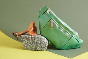 bolsa de cinturón verde hecha de cuero ecológico sobre una piedra, cuero vegano del concepto de micelio de hongos foto
