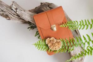 brown bag made of eco leather, mushrooms and fern on a gray background photo