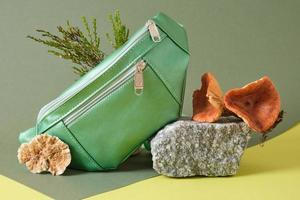 green belt bag made of eco leather on a stone, vegan leather from mushroom mycelium concept photo