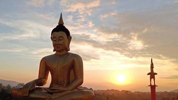 bela estátua dourada de buda contra o céu pôr do sol no templo da tailândia video
