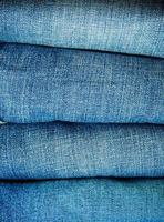 Pile of blue jeans, fabric texture photo