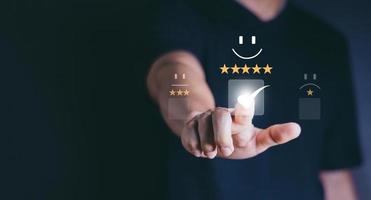 servicio al cliente y concepto de satisfacción, gente de negocios tocando la pantalla virtual en el icono de la cara feliz para dar satisfacción en el servicio. calificación muy impresionado. foto