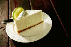 Thai style lime cream cake on white ceramic plate and wooden table. photo