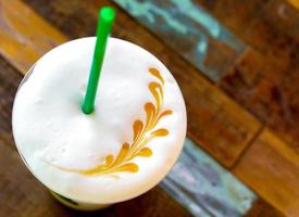 Top view of Latte art on ice Latte's milk froth and old wooden background. photo