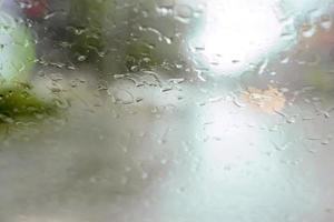 vista de los ojos del conductor de las gotas de lluvia en el parabrisas del coche en un día lluvioso. foto