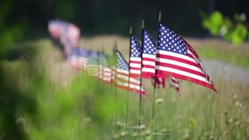 larga fila de banderas americanas en la valla ondeando en el viento. video