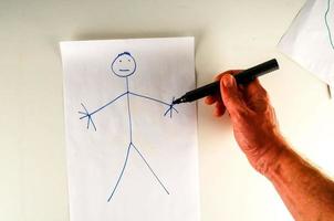 Hand drawing a stick figure on paper photo