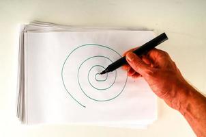 Hand drawing a spiral on paper photo