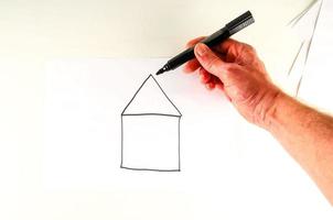 Hand drawing a house on paper photo