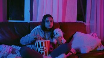 kvinna reagerar till film medan sittande på soffa med popcorn video