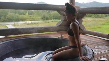 mujer se mete en un jacuzzi al aire libre video