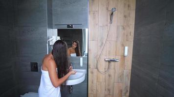 Frau nach der Dusche, die sich vor dem Spiegel fertig macht video