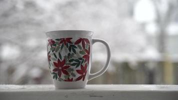 Entspannen und Kaffee oder Tee trinken, die Tassen Kaffee an einem Schneetag, auf dem Balkon. Entspannungskonzept. unscharfer hintergrund von schönem. video