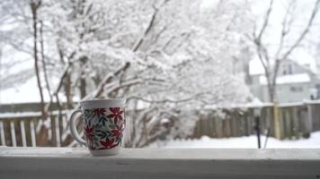 avkopplande och dricka kaffe eller te, den koppar av kaffe på en snö dag, på balkong. avslappning begrepp. suddig bakgrund av skön . video