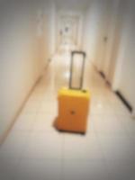 Defocused blurred photo of a yellow suitcase