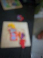 Defocused blurry shot of a boy's hand holding a wooden puzzle photo