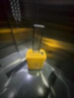 Defocused blurred photo of a yellow suitcase