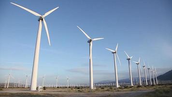 gran grupo de turbinas eólicas girando en el desierto. video