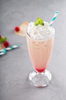 Iced milkshake with raspberry syrup and whipped cream photo