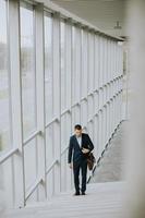 Young business executive with briefcase going up the stairs photo