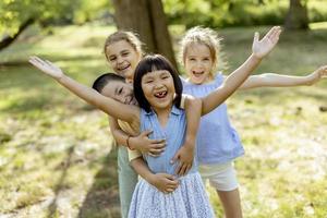 grupo de niños asiáticos y caucásicos divirtiéndose en el parque foto