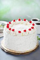 Coconut cake with maraschino cherries photo