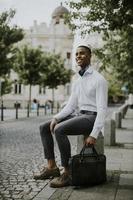 Young African American businessman waitng for a taxi on a street photo