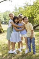 grupo de niños asiáticos y caucásicos divirtiéndose en el parque foto