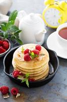 Stack of fluffy buttermilk pancakes with raspberry and coconut photo