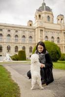 hermosa joven feliz con un lindo cachorro de perro pequeño diviértete en la calle foto