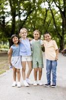 grupo de niños asiáticos y caucásicos divirtiéndose en el parque foto