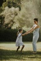 Cute little girl having fun on a grass with her mother photo