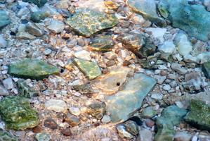 piedras en agua de mar foto