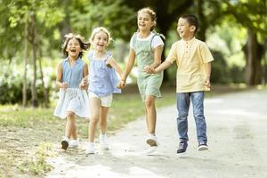 grupo de niños asiáticos y caucásicos divirtiéndose en el parque foto