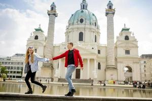 pareja joven caminando por st. iglesia católica de pedro en viena, austria foto