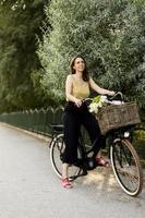 mujer con flores en la cesta de la bicicleta eléctrica foto