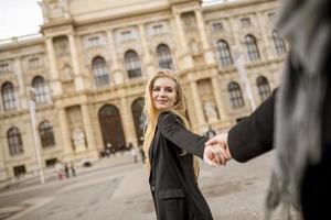 Two young women walking on the street and holding hands photo