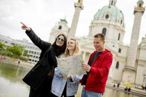 jóvenes turistas mirando el mapa callejero de viena, austria foto