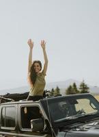 Young woman enjoying freedom in terrain vehicle on a sunny day photo
