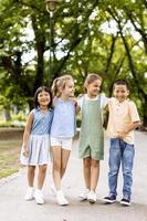 grupo de niños asiáticos y caucásicos divirtiéndose en el parque foto