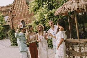 Group of young people cheering and having fun outdoors with drinks photo