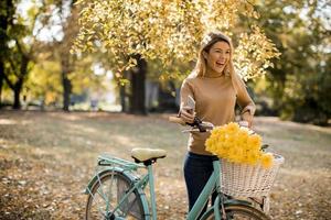 Happy active woman riding bicycle in autumn park