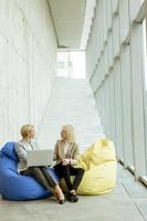 Businesswomen using laptop computer on lazy bags in the modern office photo