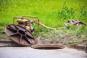 Plumber's tools near opened manhole photo