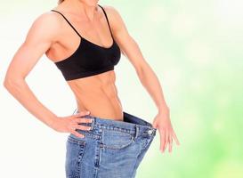 woman with strong abs shows her old big jeans photo